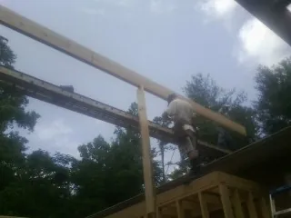 Carpenter setting a ridge beam over a new addition frame — Ice Dam Removal by Roofing Brothers in Saratoga